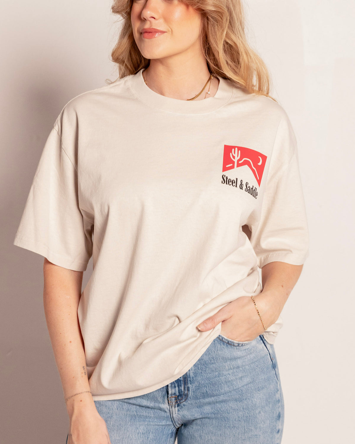 Cowboy Killer Tee in faded bone on model, front view with the small red pack chest print