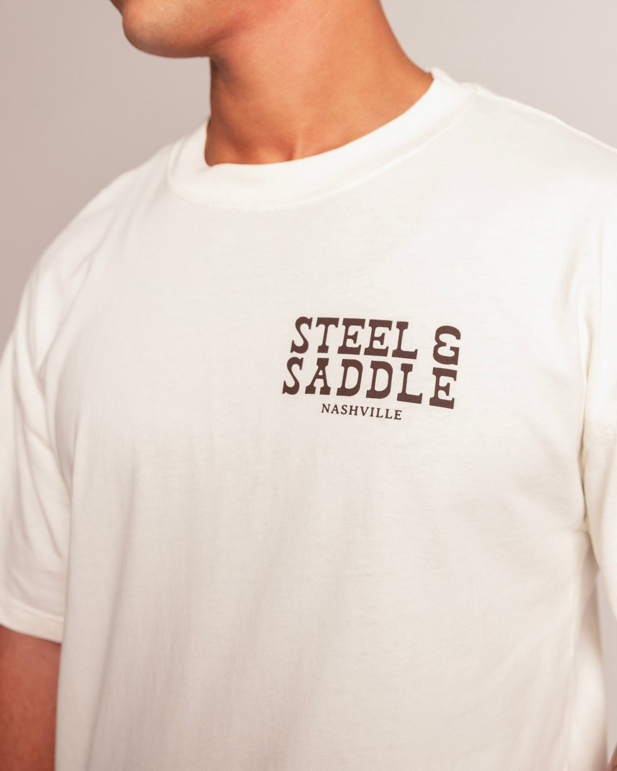 Holdup Tee in faded ecru, close-up of the Steel & Saddle Nashville chest print