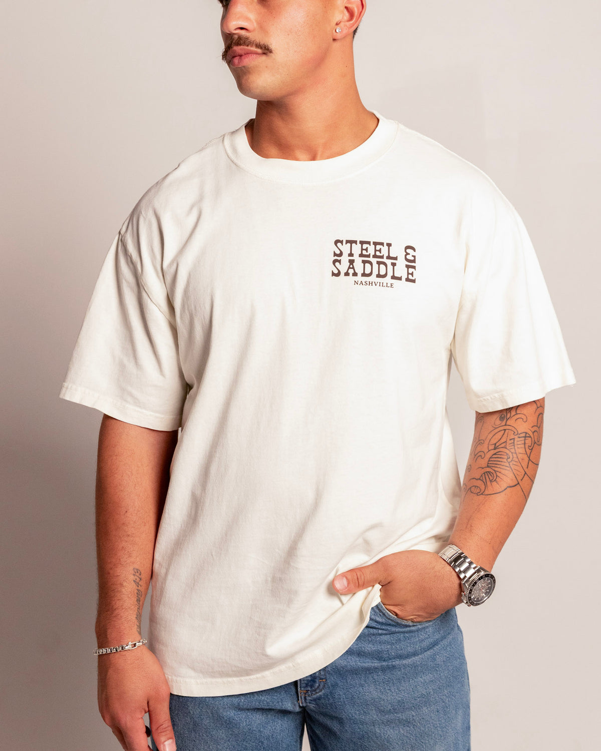 Holdup Tee in faded ecru on model, front view with the Steel & Saddle Nashville chest print
