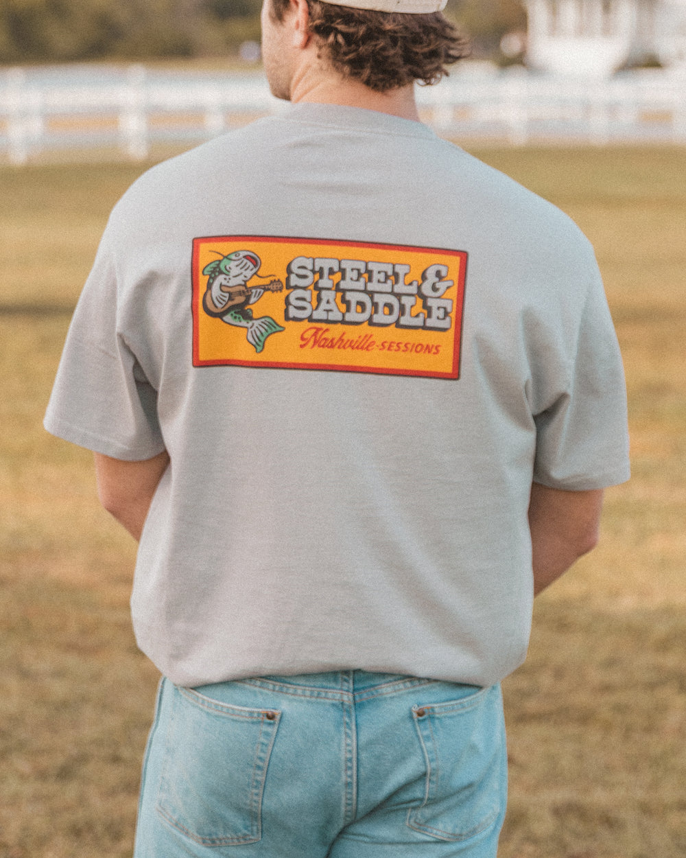 Nashville Sessions Tee in faded storm worn outdoors, back print of a catfish playing guitar on an orange patch
