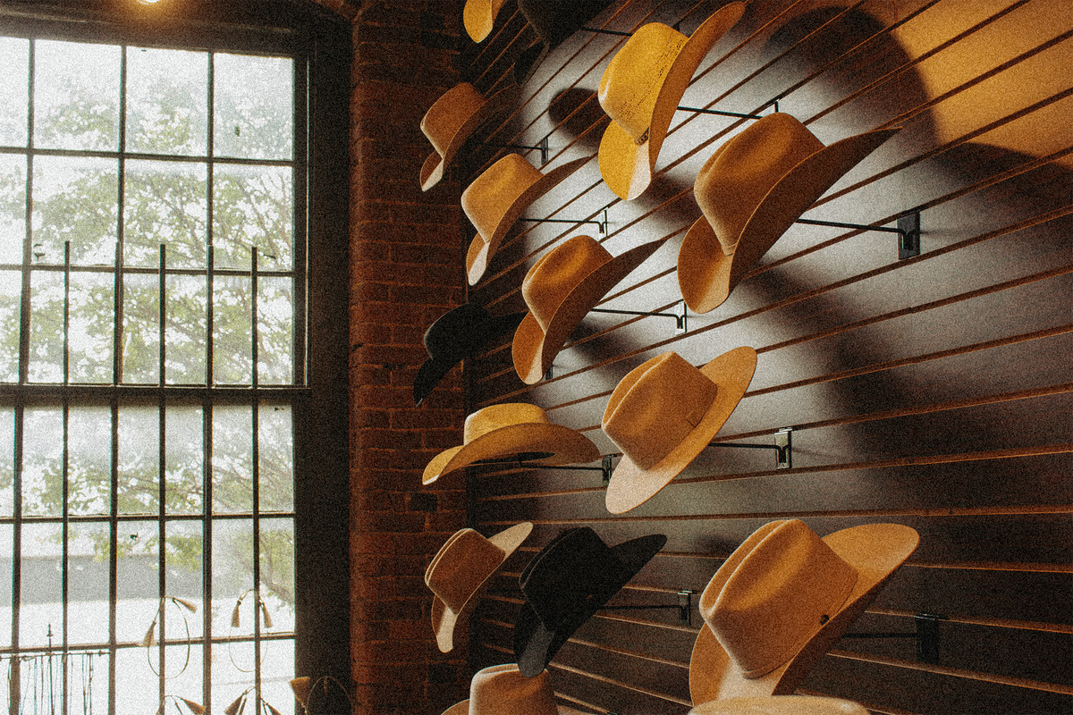 Cowboy hat wall beside a tall window inside the Steel & Saddle shop in Marathon Village, Nashville